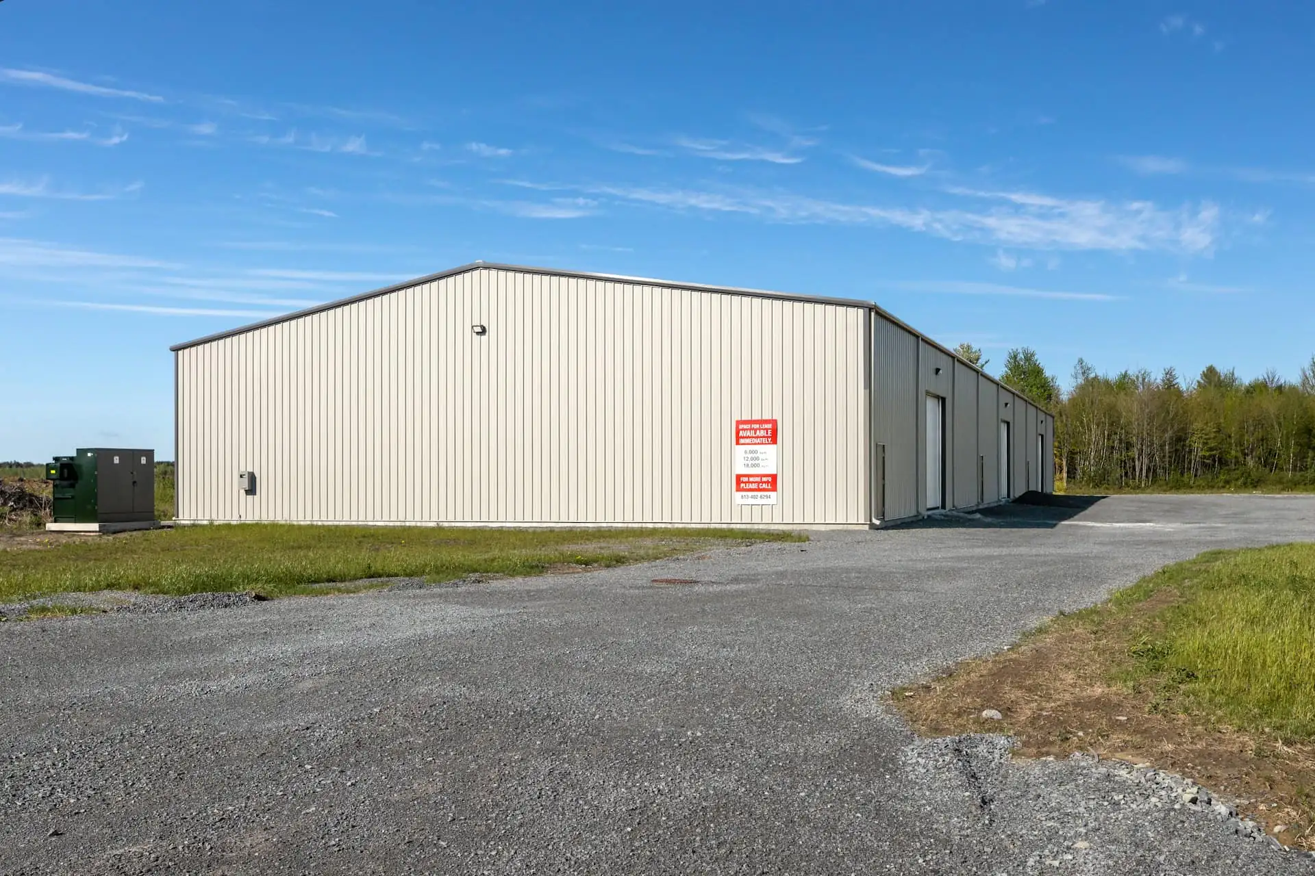 Small steel-frame warehouse with a double roller door, an office block and a concrete yard
