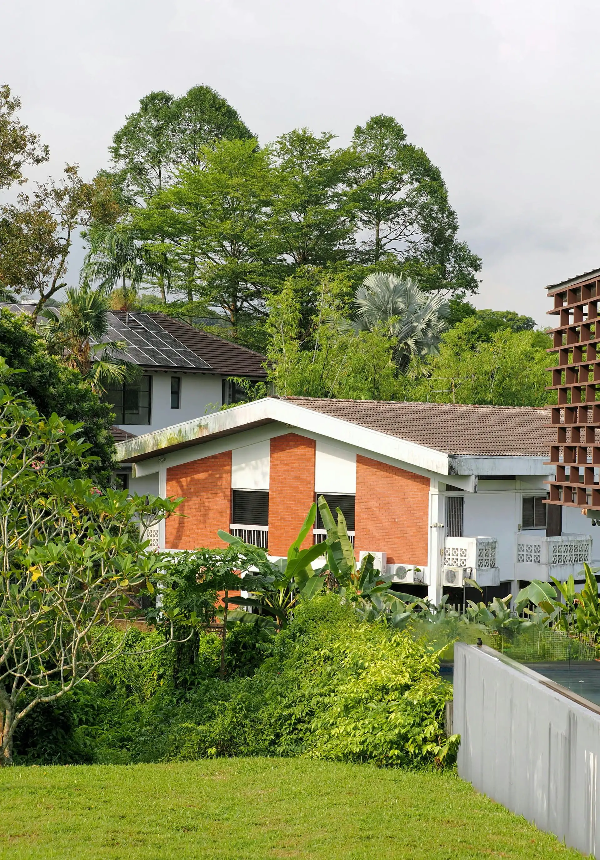 Large double-storey house with a hip roof, stone-effect feature wall and landscaped front yard
