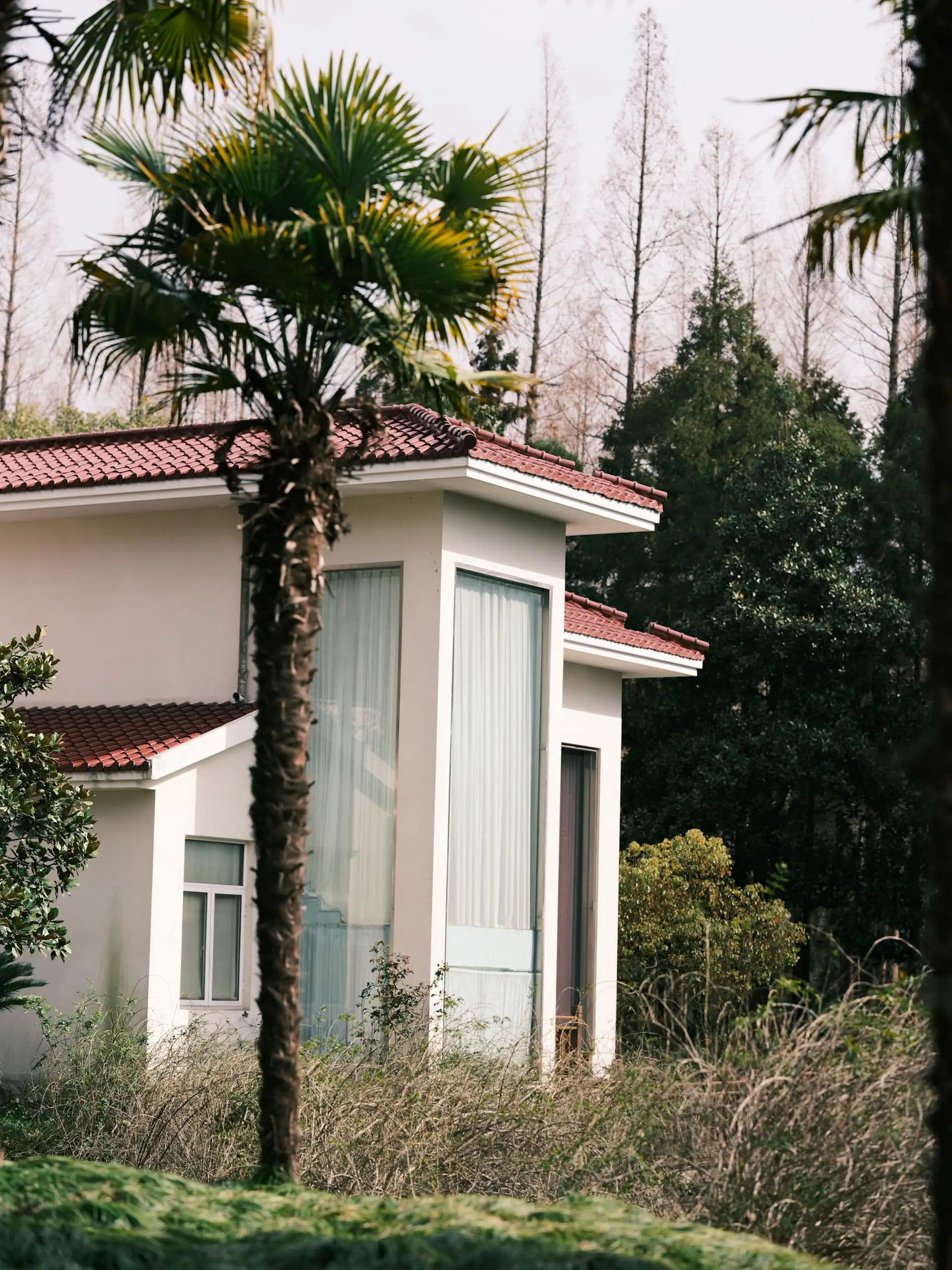 Newly finished modern two-storey home with a grey facade and a covered porch, under a blue sky