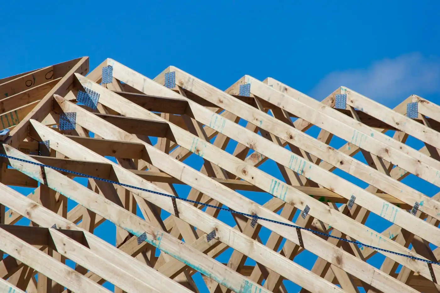 Roof trusses with long overhanging eaves being assembled over a single-storey house
